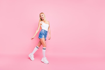Full body photo of funky lovely girl have promenade walk wear white tank-top shorts denim jeans isolated over pink color background