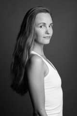 Naklejka premium Young beautiful woman with long blond hair against gray background