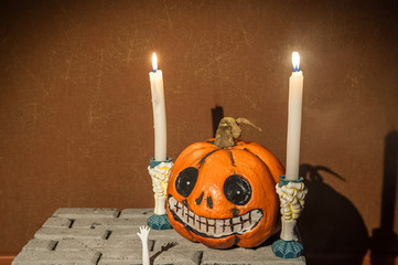 Halloween holiday concept. Pumpkin with a face. Burning and extinguished candles. Background for...