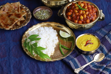 dishes of national Indian cuisine on a dark blue background. traditional Indian home-cooked dinner. rice, dal, sabji, aloo parantha, gulabjamun, masala