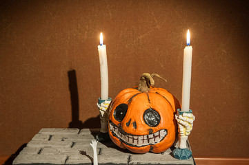 Halloween holiday concept. Pumpkin with a face. Burning and extinguished candles. Background for...