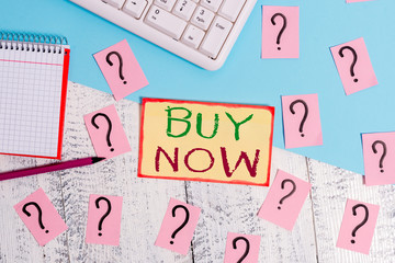 Text sign showing Buy Now. Business photo text asking someone to purchase your product Provide good Discount Writing tools, computer stuff and math book sheet on top of wooden table
