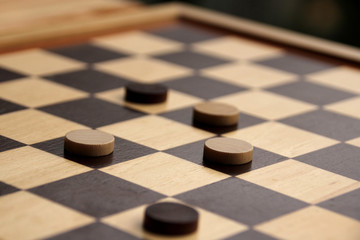 wooden checkers white and dark brown on a chessboard, game concept