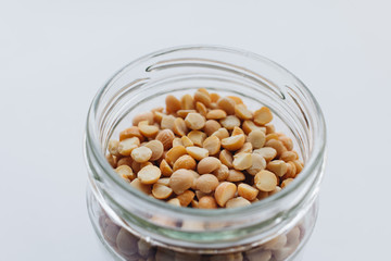 Glass jar with raw dry peas, macro