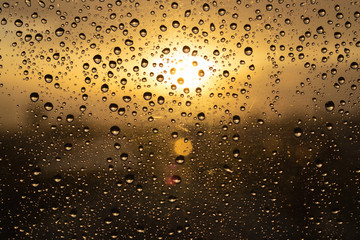 Water droplets on the glass. The sun shines through the window during the rainy time.