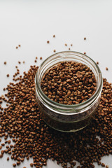 Raw buckwheat in glass on white background, heathy food, diet