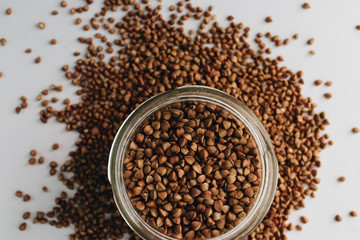 Raw buckwheat in glass on white background, heathy food, diet