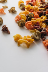 Pile of uncooked bright macaroni on white background