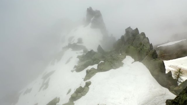 Aerial: Snowy Mountain Ridge with Amazing Cliffs in Thick Fog - Le Brevent, France