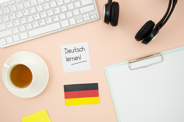 Different learning objects with german flag on peach background