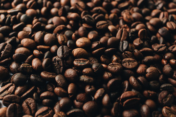 Close-up view of roasted coffee beans and glass cup