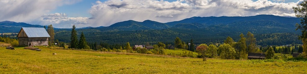 Obraz premium panorama landscape with mountains and clouds and village in the mountains