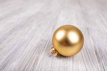 gold christmas ball on a white wooden background