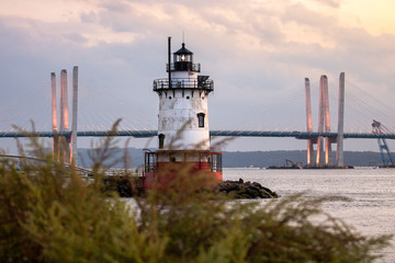 Caisson (sparkplug) style lighthouse under soft golden light with a bridge in the background. Tarrytown Light on the Hudson River in New York.  - obrazy, fototapety, plakaty