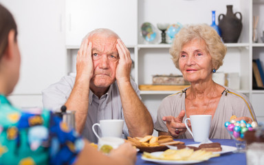 Fototapeta na wymiar Upset elderly pair having tough talk with girl