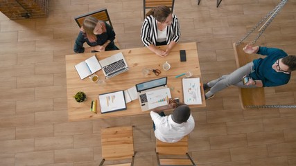 Top View of Casual Diverse Team Applauding to Leader or Manager in Startup Loft Office. Overhead Happy Teamwork Celebrating Success. 4K High Angle Long Background Shot