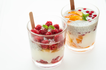 Two glass of parfait made from Greek yogurt with Mixed Berries on a white backgrounds. Healthy desserts concept