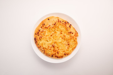 Fresh round cake on white plate on white background.
