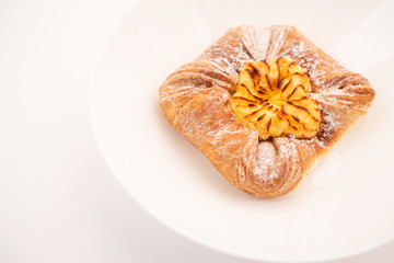 Fresh bun of unusual shape on white background.