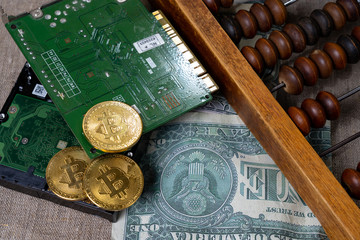 Bitcoin blockchain cryptocurrency concept. Bitcoins in the form of coins lie on microchips and dollars next to abacus. Cryptocurrency earnings symbol.