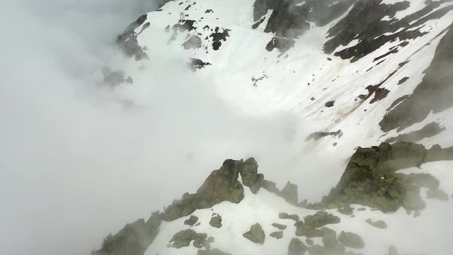 Aerial Tilt-up: Snowy Mountain Ridge with Awesome Cliffs in the Clouds - Le Brevent, France