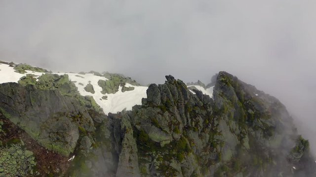 Aerial Tilt-down: Snowy Mountain Ridge with Amazing Cliffs in the Clouds - Le Brevent, France