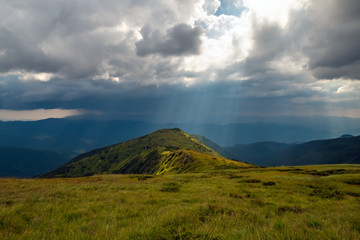 Storm clouds and sun rays over the mountains