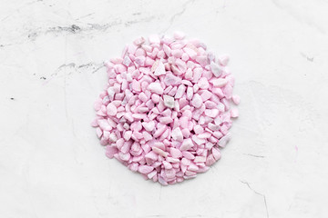 little stones and roses design on marble background top view