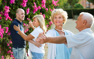 Adult friends dancing pair dance in garden