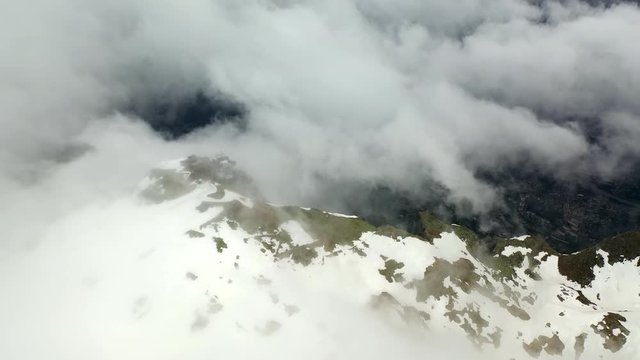 Aerial: Cable Car Station on top of Amazing Snowy Mountain in the Clouds - Le Brevent, France