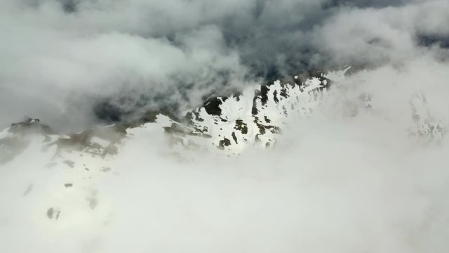 Aerial Tilt-down: Cable Car Station on top of Amazing Snowy Mountain in the Clouds - Le Brevent, France