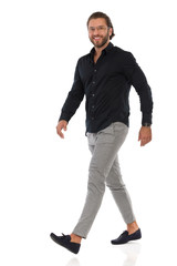 Fototapeta premium Confident Elegant Man Is Walking And Looking At Camera. Side View.