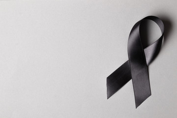 Black ribbon on a gray background. Mourning. Sorrow. - obrazy, fototapety, plakaty