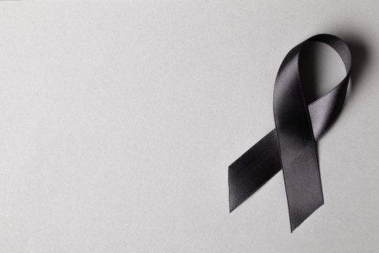 Black Awareness Ribbon With White Candle On White Background