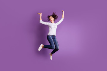 Full length body size photo of charming overjoyed jumping recjoicing girlfriend wearing jeans denim footwear ecstatic isolated over purple pastel color background