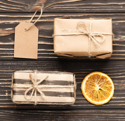 Composition of craft gift boxes on brown wooden background.