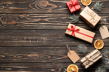 Flat lay Composition from Kraft gift boxes, pine cone, fir branches, Dried orange fruits, on a brown wooden background. Place for text. Top view.