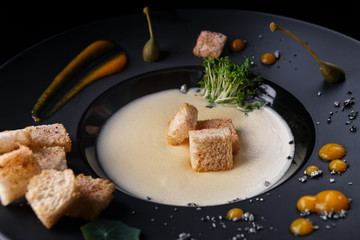 Mushroom cream soup on a black plate