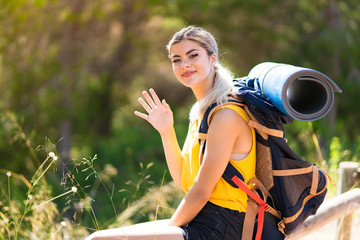 Teenager girl hiking at outdoors and saluting