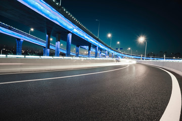 Empty road floor with city viaduct bridge of neon lights night
