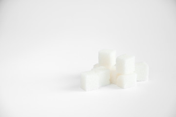 sugar cubes lie on a white table. Refined