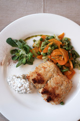 tasty fish breaded with vegetables and microgreens