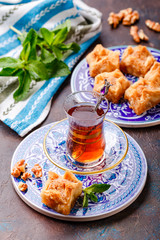 Traditional Turkish arabic dessert and a glass of tea with mint