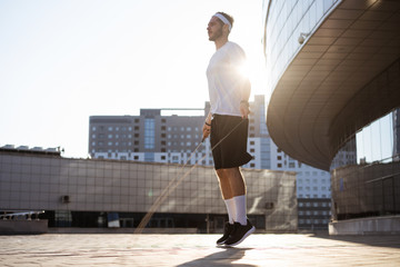 Young man jumping rope outside