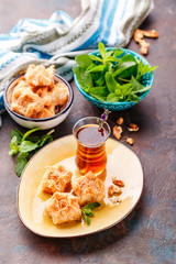 Traditional Turkish arabic dessert and a glass of tea with mint