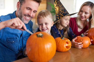 Fototapeta na wymiar Family drilling pumpkins for Halloween