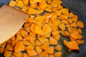 Fried vegetables in a griddle. Carrots fried in a frying pan. Finely chopped carrots in a frying pan
