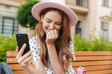 Young redhead woman talking by mobile phone.