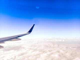 Fototapeta na wymiar Wing of the plane on blue sky background . Airplane Wing in Flight from window, blue sky . travel concept idea .
