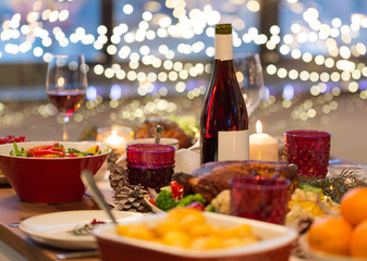 christmas dinner and eating concept - food and drinks on table at home